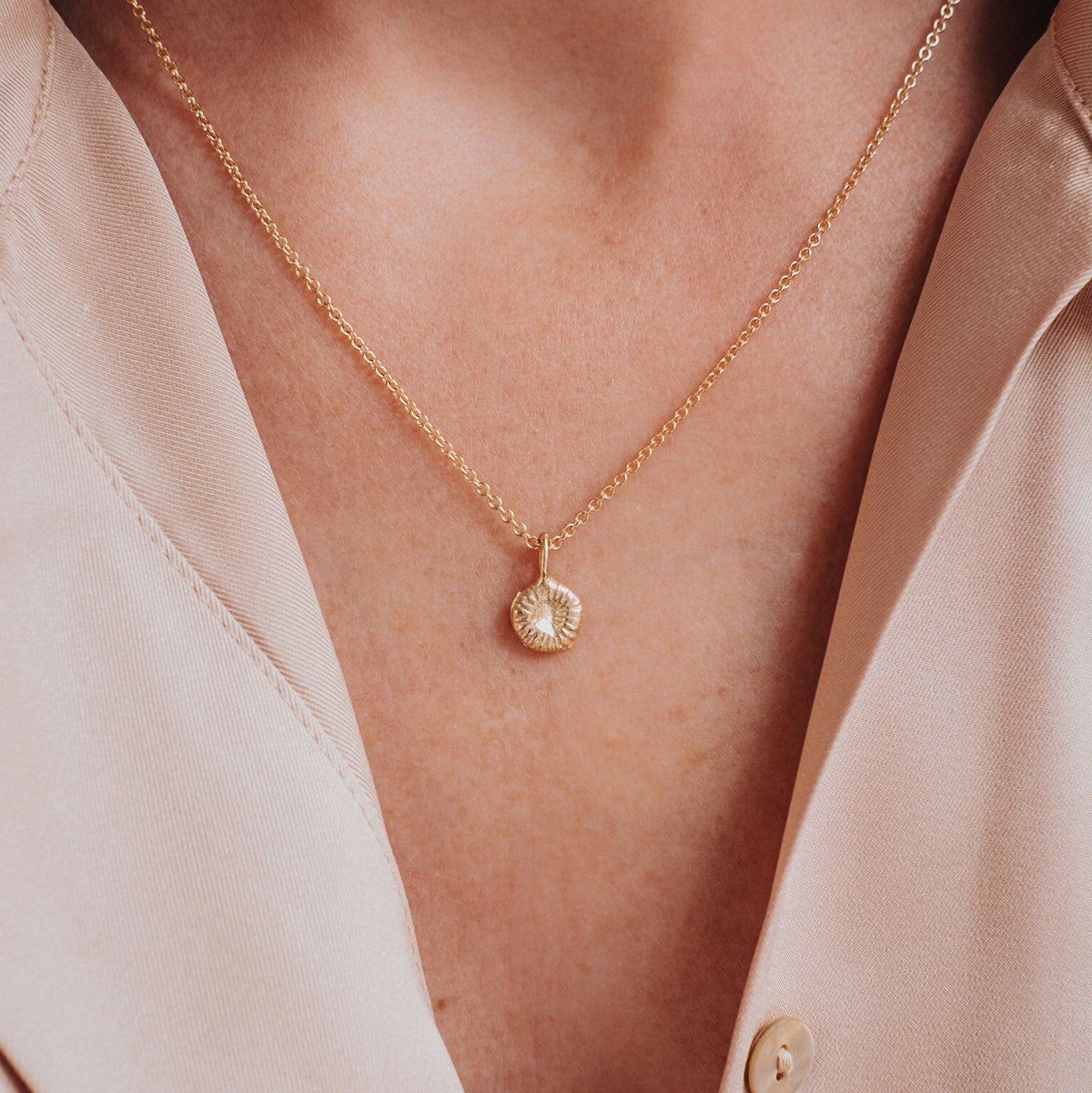 Knappkorallhalsband i guld på modell