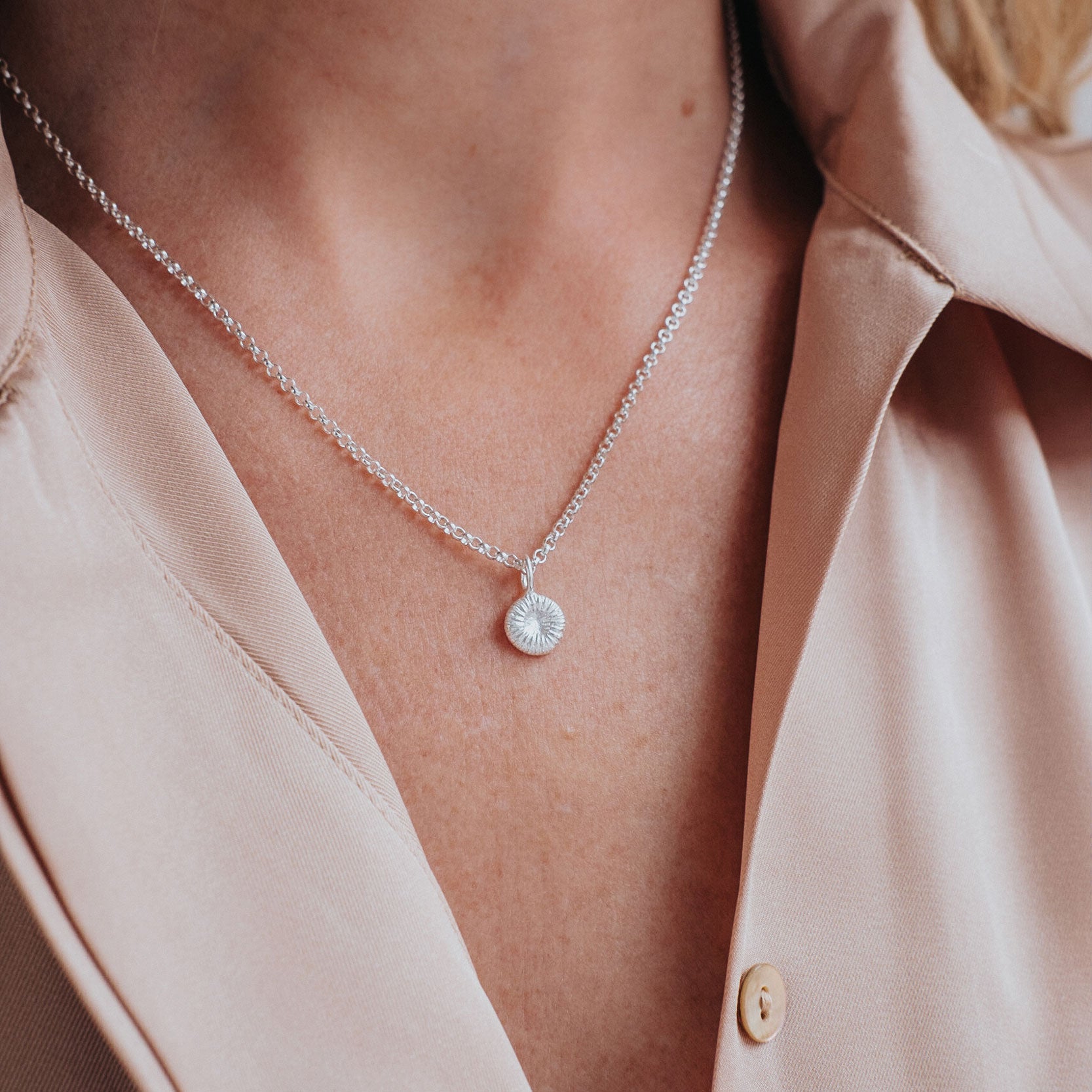 Silverhalsband med knappkorall på modell