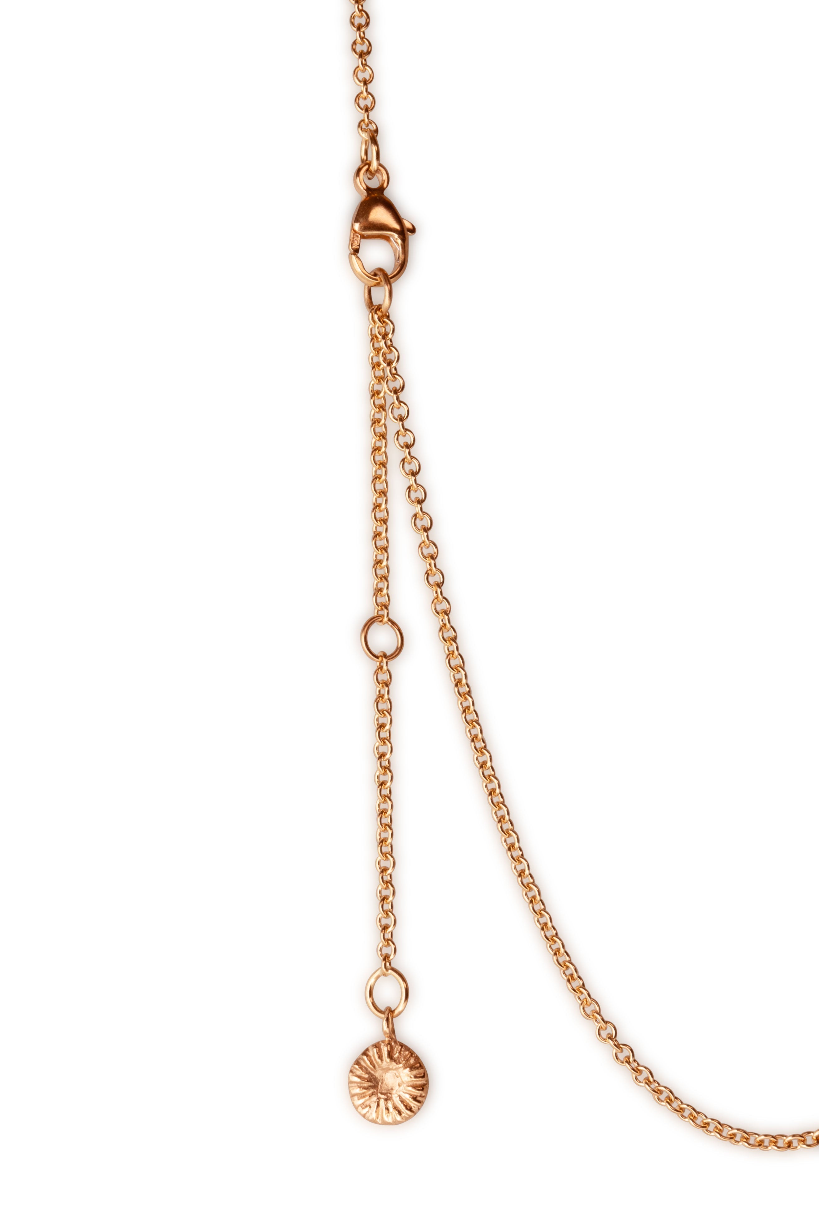 Närbild av guldknappkorall halsbandets lås