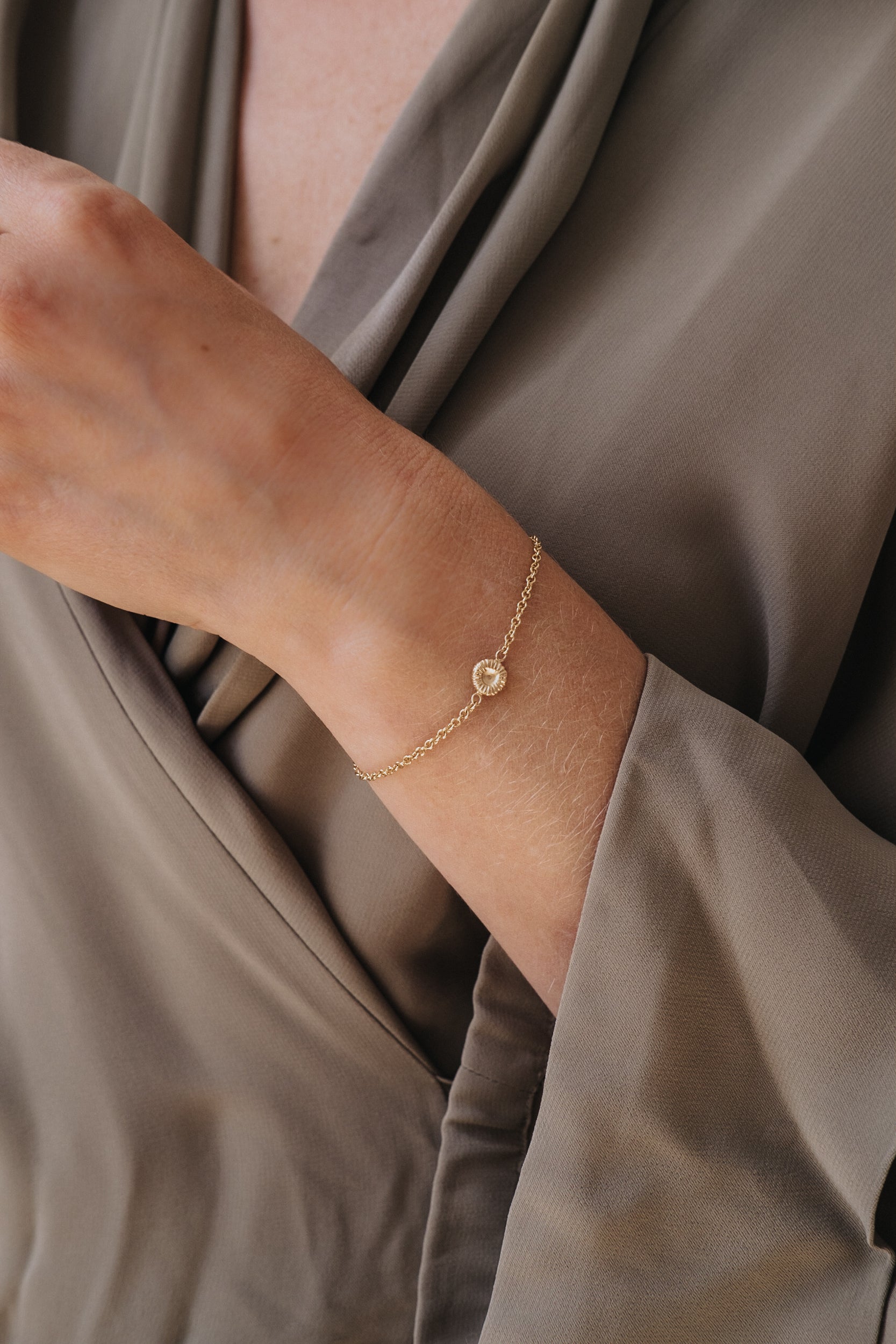 Guldarmband med knappkorall på handled